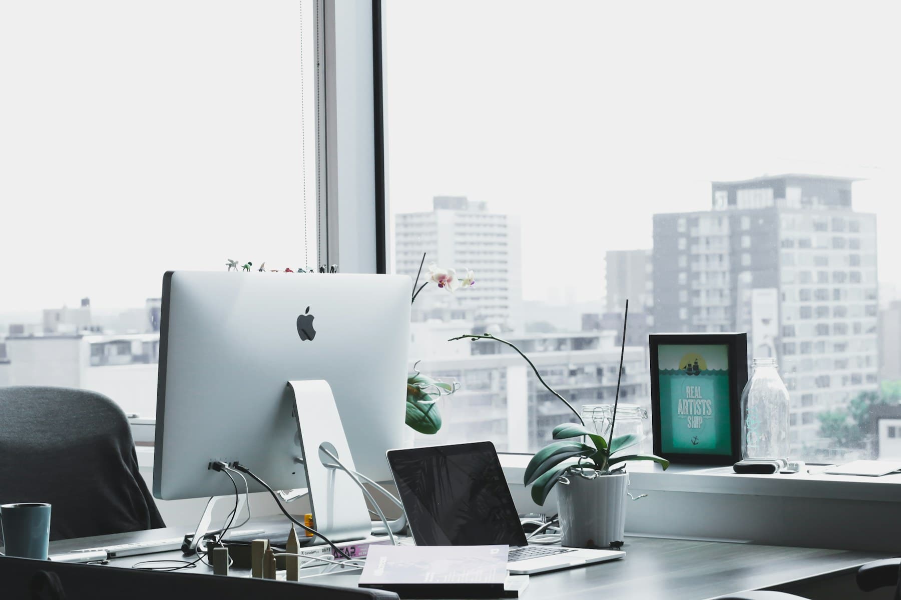 Heller Arbeitsraum mit Tisch, Laptop und Notizen für konzeptionelle Arbeit